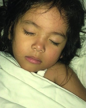 The same girl asleep with her lips closed.